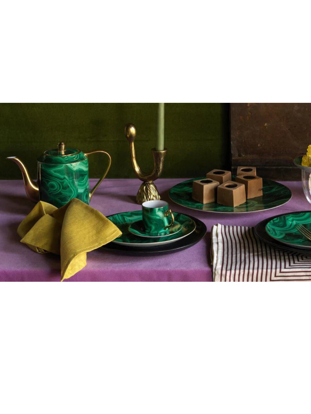Elegant green marble-patterned teapot, cup, and plates on a decorated dining table