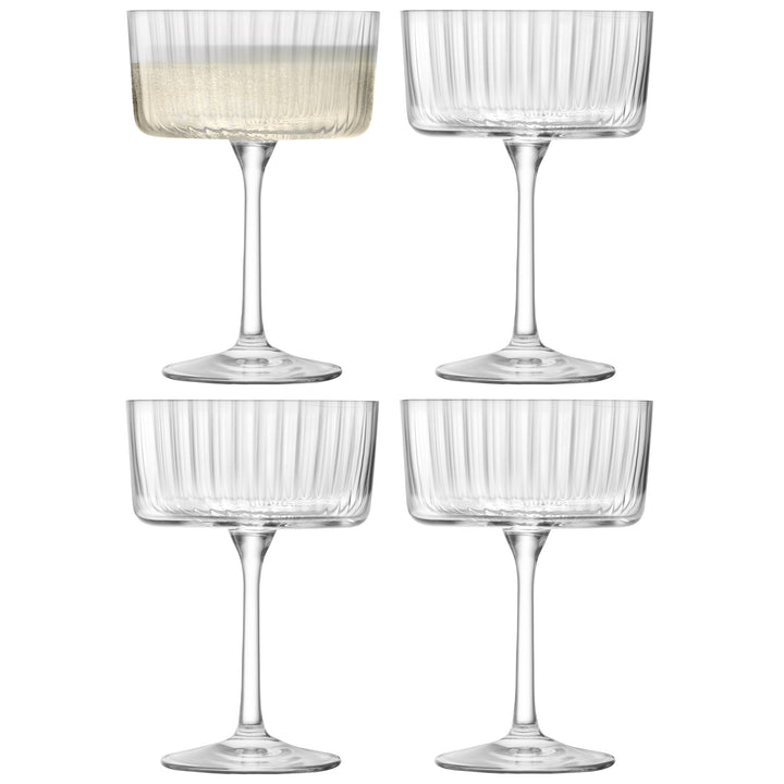 Set of four DecoDine clear ribbed champagne cocktail glasses, one with sparkling wine